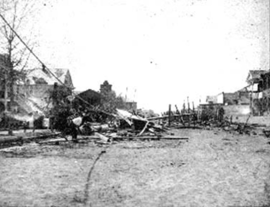 G-1771FF7.11-13 Man examining debris in residential street