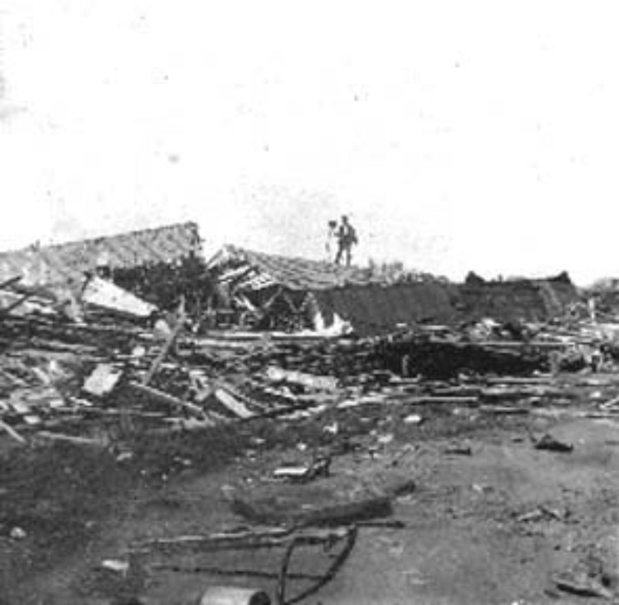 G-1771FF7.12-10 Photographer with his camera standing on roof of demolished house