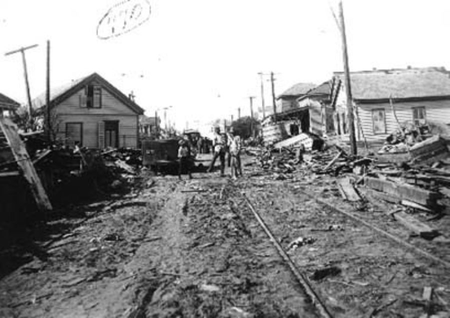 G-1771FF7.3-4 Looking down street lined with wrecked houses and debris