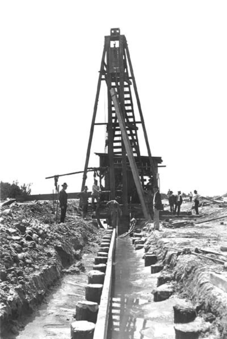 G-5925.1FF1-13 Workmen driving piles along beach